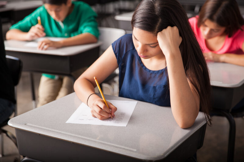 group high school students taking test classroom